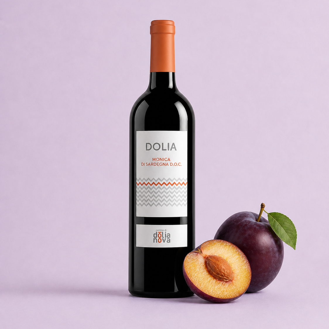 Dolia Monica red wine bottle with ripe plum on a pink background, Sardinian wine by Cantina di Dolianova