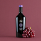Anzenas Cannonau di Sardegna red wine bottle with red grapes on deep red background