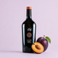 Arenada Monica di Sardegna red wine bottle with fresh plum on a soft light background