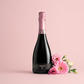 Cáralis Brut Rosé Sardinian sparkling wine bottle with pink flowers on a soft pastel background