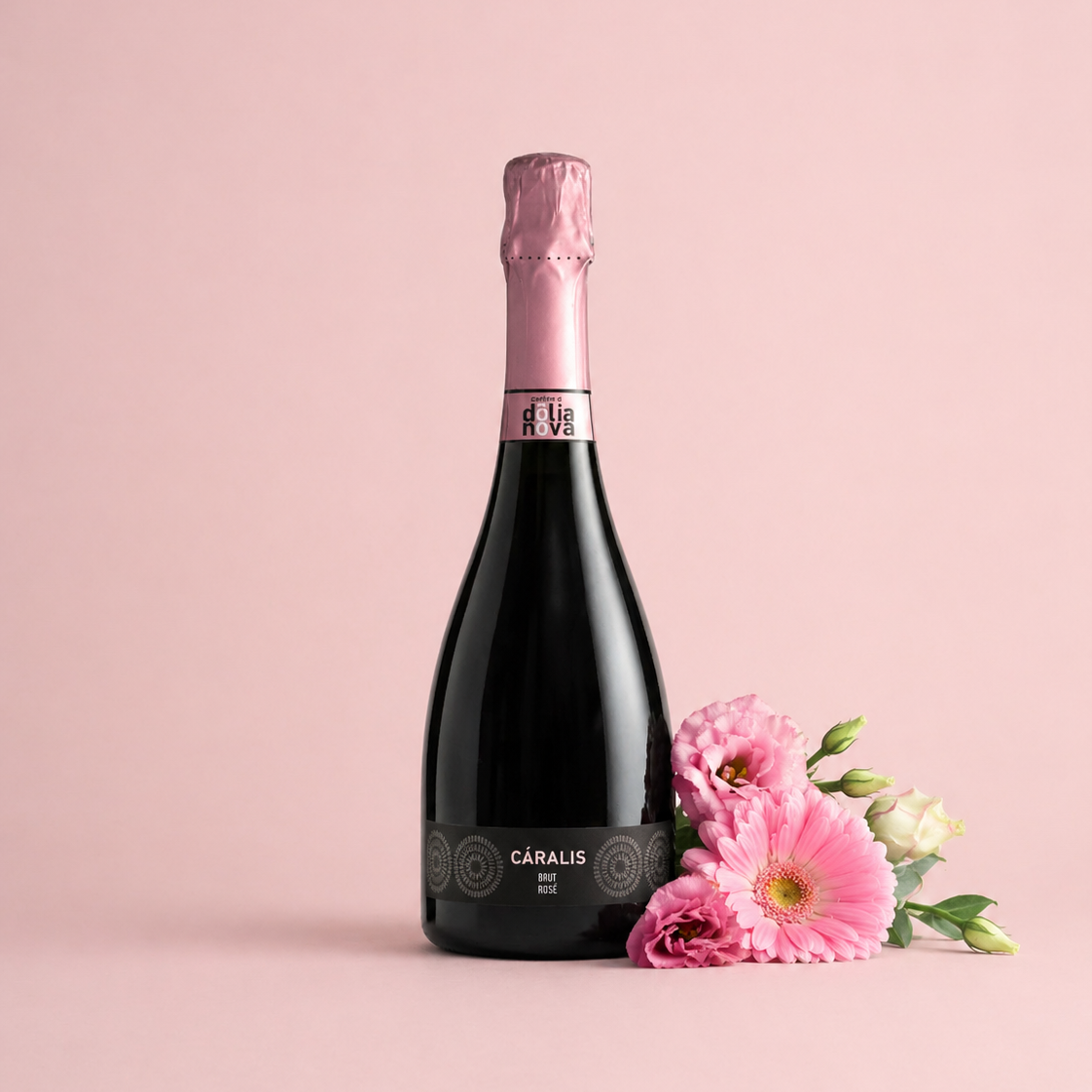 Cáralis Brut Rosé Sardinian sparkling wine bottle with pink flowers on a soft pastel background