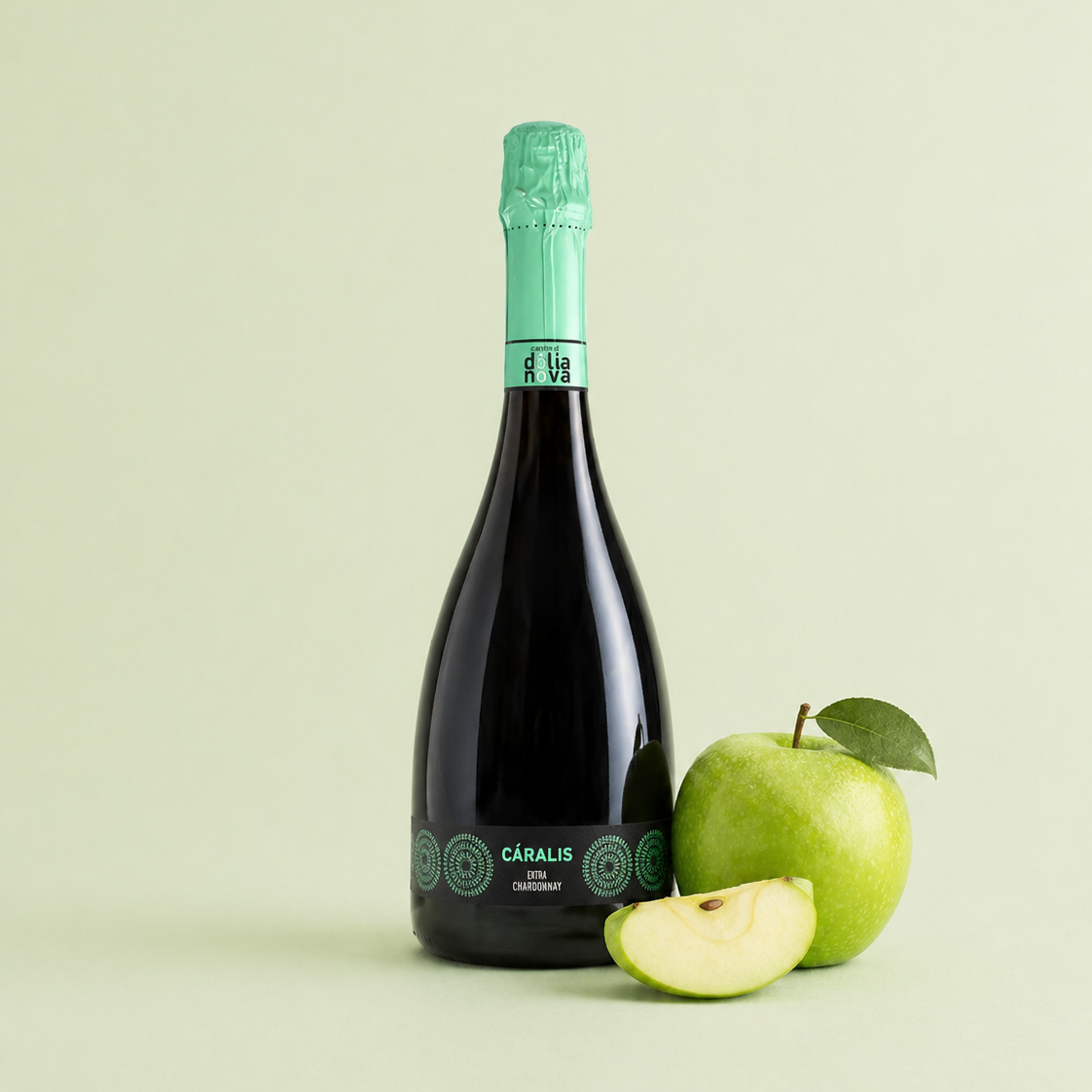 Càralis Chardonnay brut sparkling wine bottle with fresh green apple on a light green background