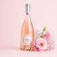 Dolì Rosé Frizzante Sardinian sparkling rosé wine bottle with pink flowers on a soft pastel background