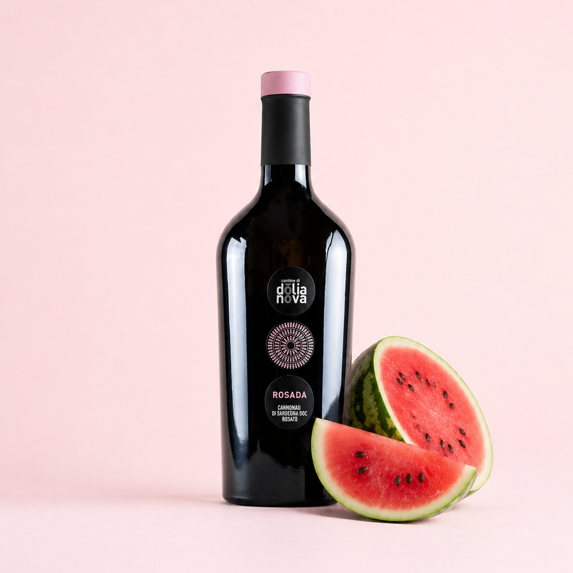 Rosada Cannonau di Sardegna rosé wine bottle with fresh watermelon on a soft pink background