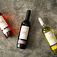 Santesu red, white and rosé Sardinian wine bottles on a textured stone background